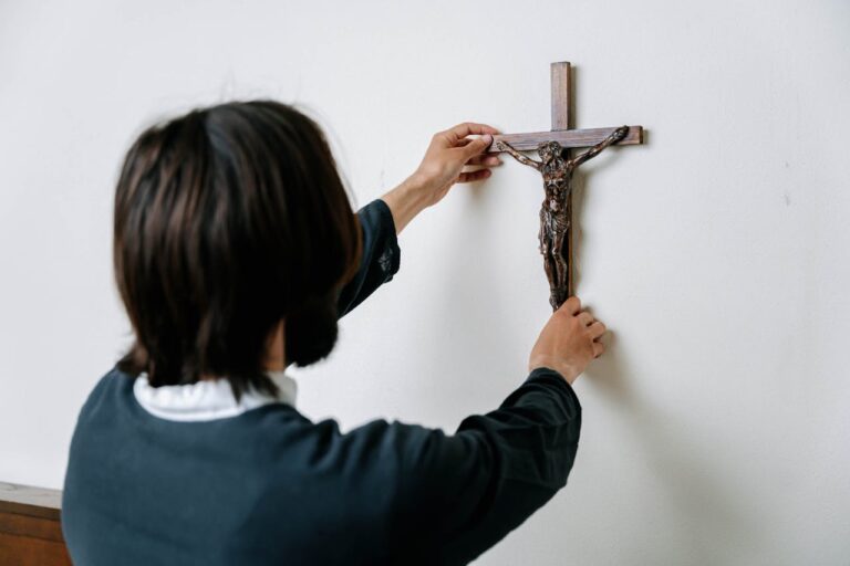 mulher-colocando-crucifixo-na-parede